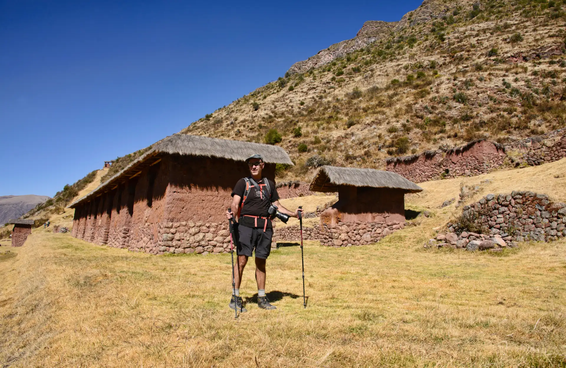Huchuy Qosqo Full Day: Conoce el Pasado Inca del Valle Sagrado Exploradores disfrutando de la vista de las ruinas de Huchuy Qosqo con el paisaje del Valle Sagrado de fondo.