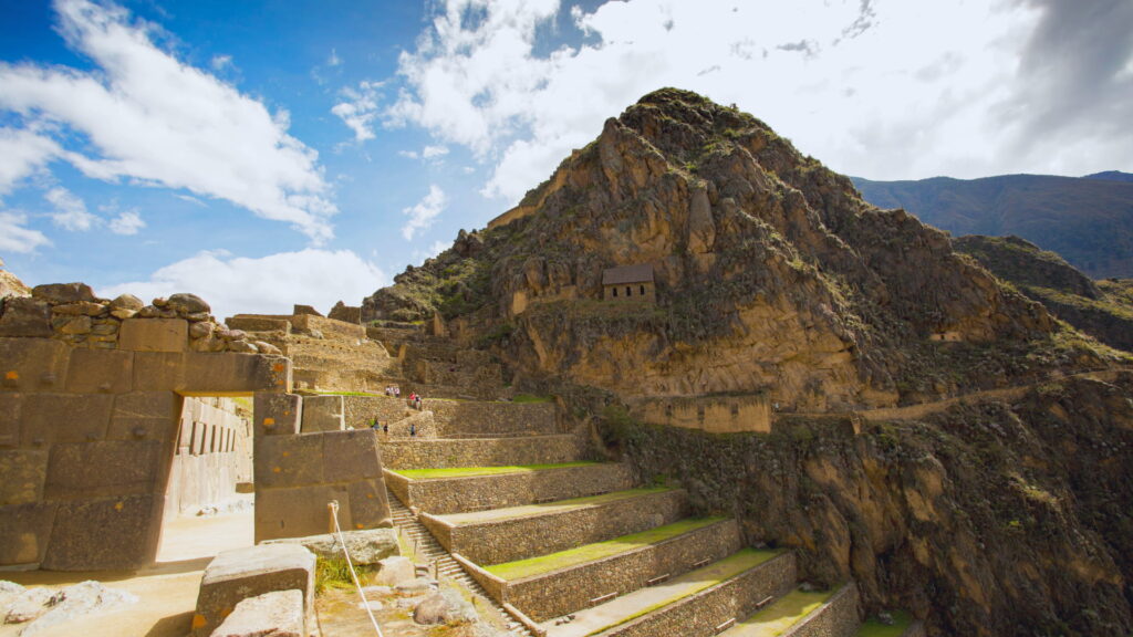 Calles empedradas de Ollantaytambo con canales de agua y casas tradicionales.