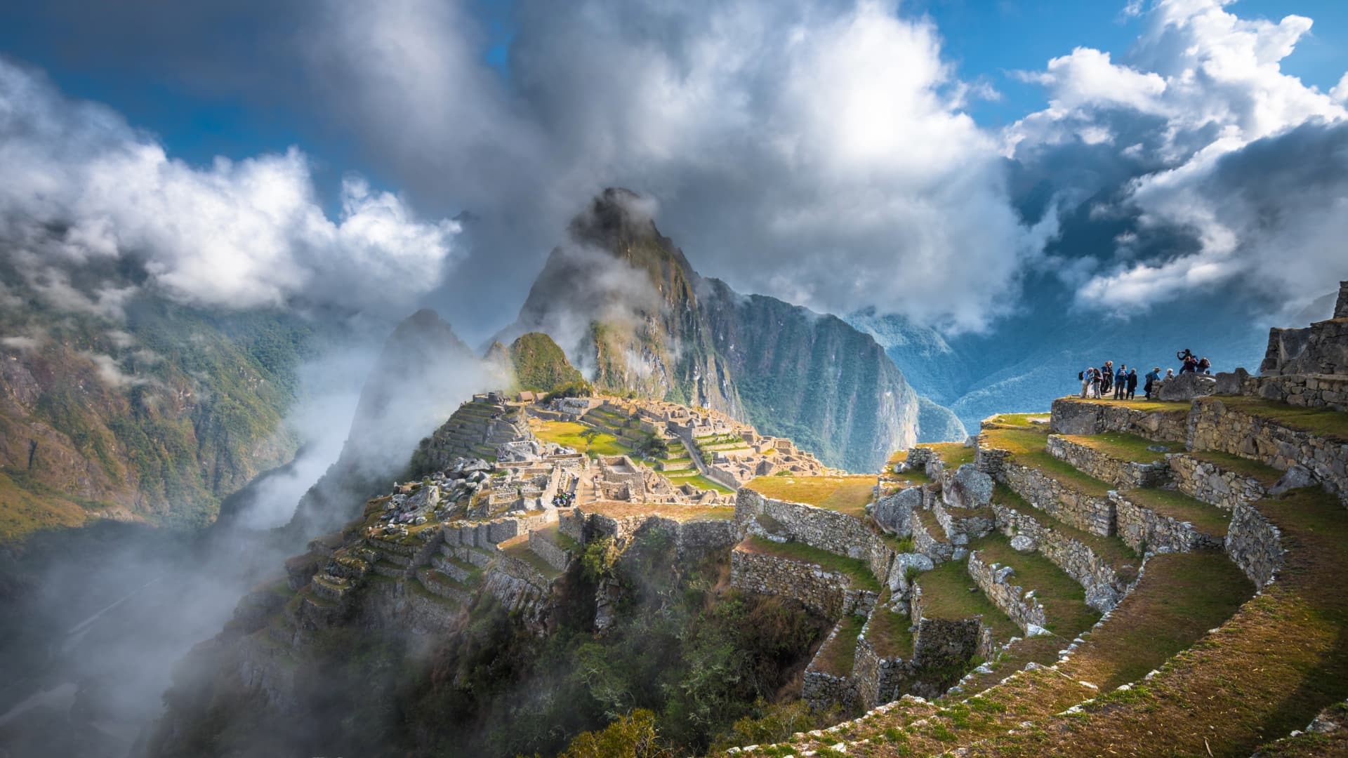 Machu Picchu: La Maravilla del Mundo te Espera en Cusco La icónica ciudadela inca de Machu Picchu con la montaña Huayna Picchu de fondo, envuelta en nubes y niebla mística al amanecer.