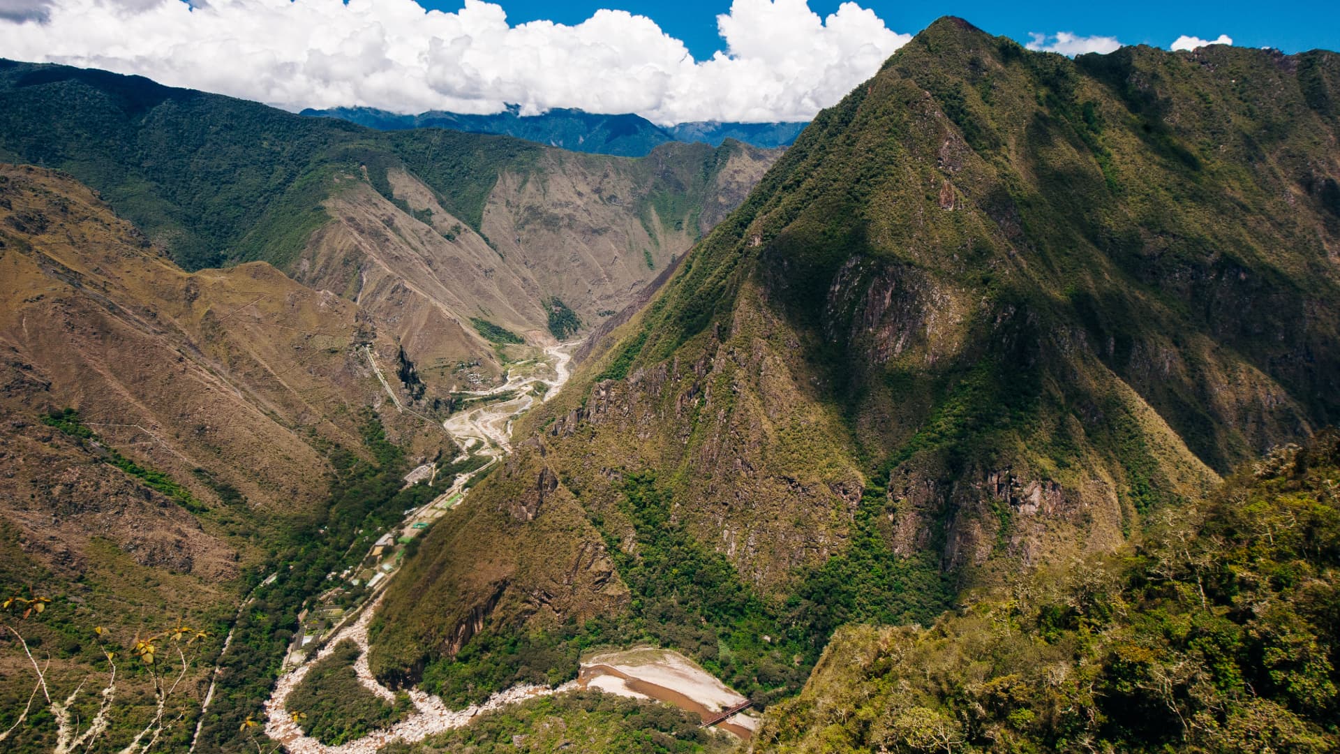 Paisaje Andino: El Impresionante Valle del Río Urubamba Vista panorámica desde lo alto del Camino Inca - Inka Jungle, mostrando el profundo cañón del río Urubamba serpenteando entre majestuosas montañas verdes.